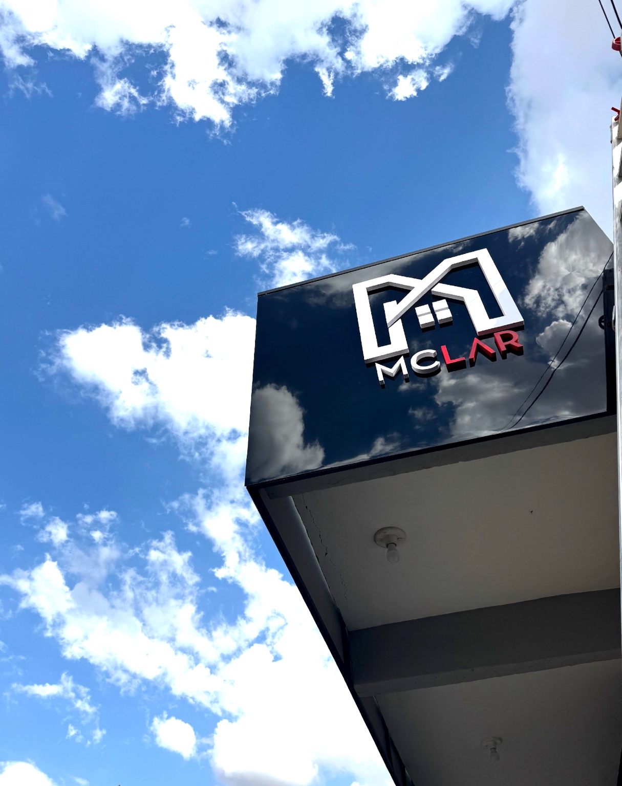 Fachada da McLar Construtora sob o céu azul